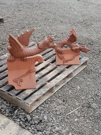 Terracotta dragons with dark detailing on a wooden pallet