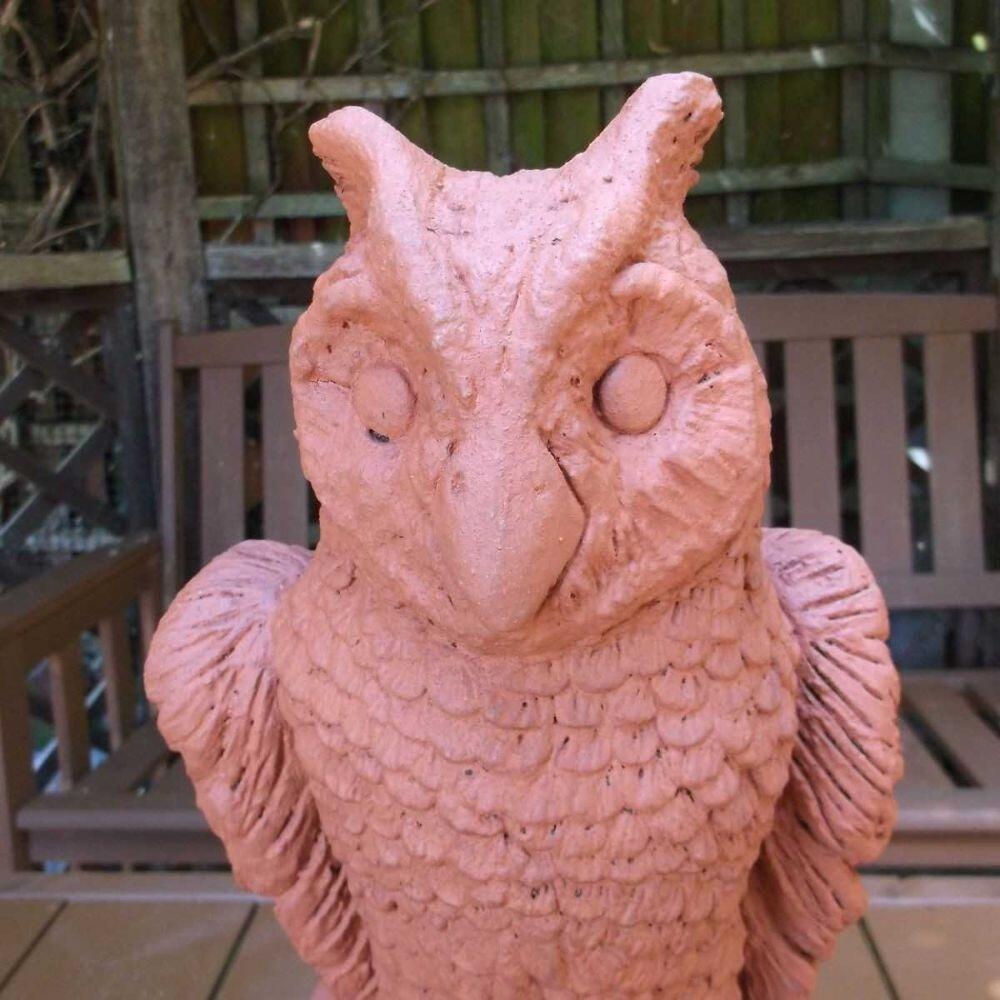 Photograph taken in the garden depicting a terracotta owl roof finial stop end cap.
