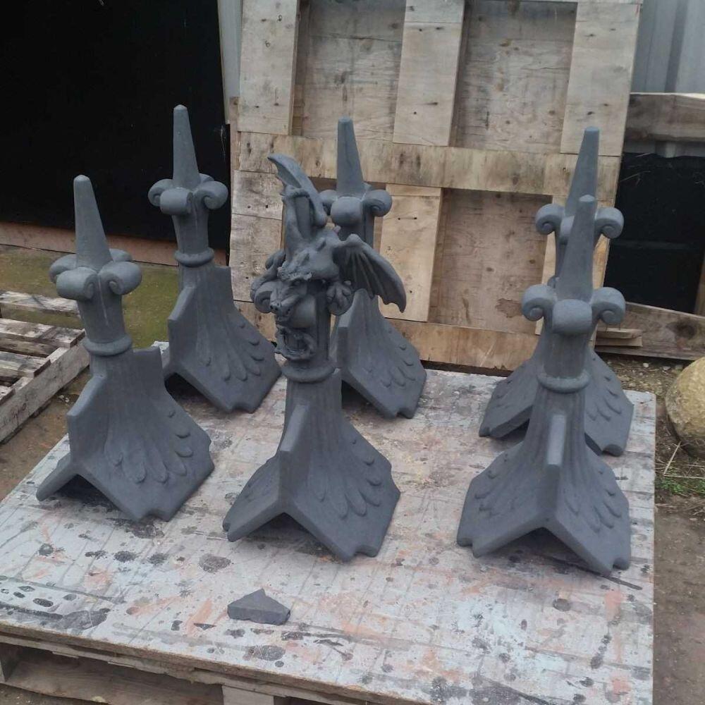 Slate grey column fleur de lis finial and finials on a pallet at the workshop