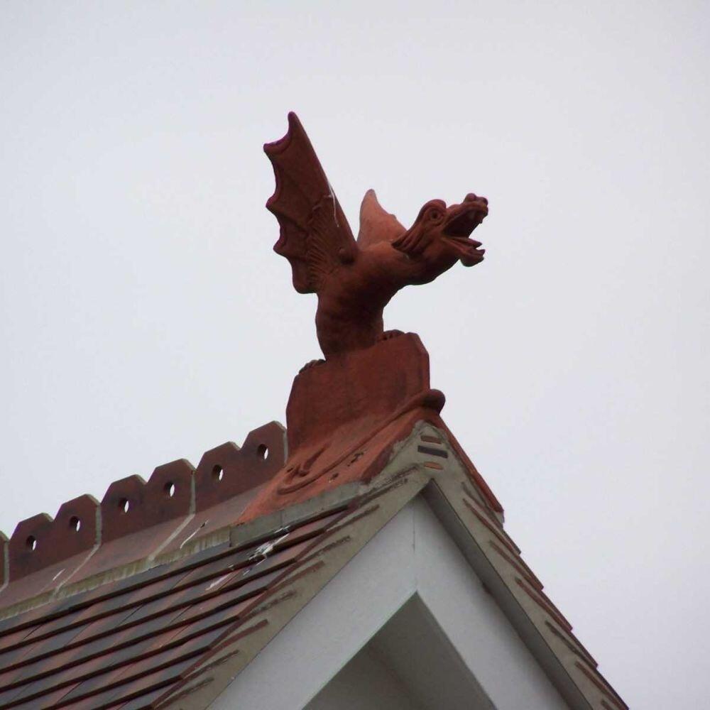 Terracotta roof wyvern finial installed on a gable roof