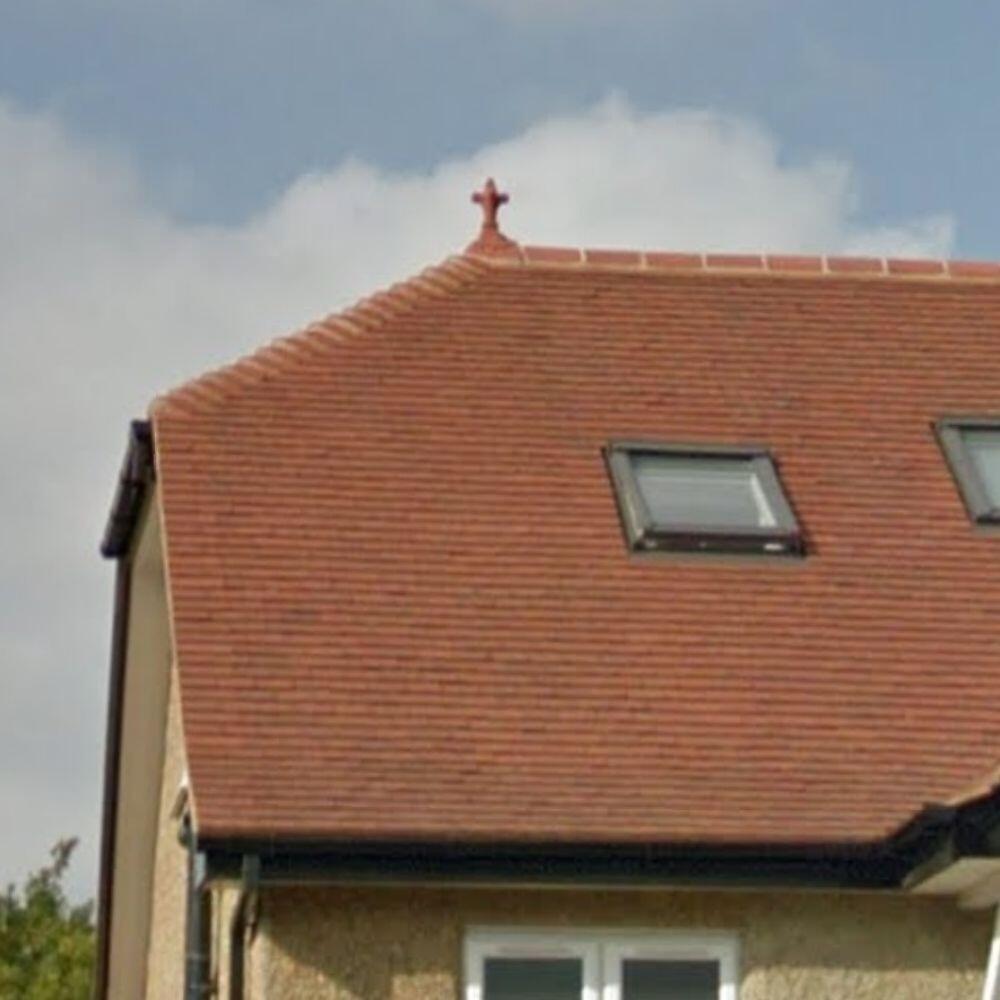 Half round old fleur block end finial installed on a roof
